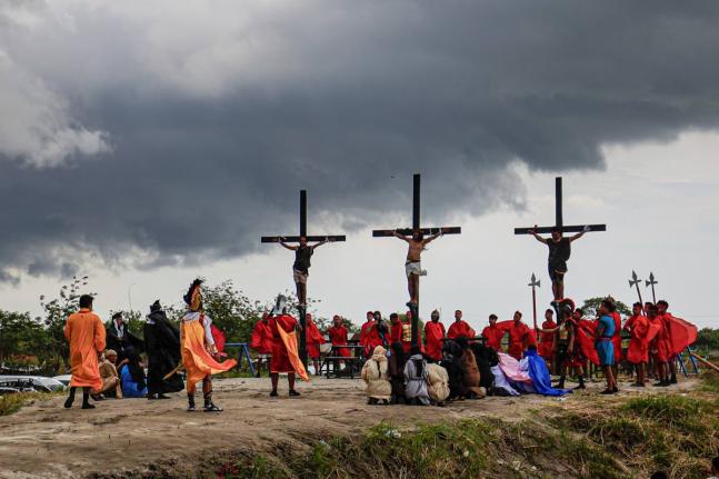 Ruben Enaje (centre) remains on the cross flanked by two other devotees during a reenactment of Jesus Christ’s sufferings as part of Good Friday rituals in San Pedro Cutud, north of Manila, Philippines.