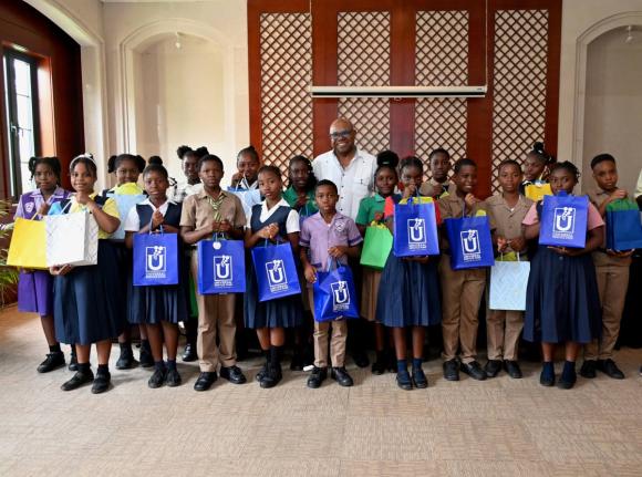 Tourism Minister Edmund Bartlett (centre), the member of parliament for St James East Central, in a group shot with several primary school students from the constituency who received computer tablets during a handover service at the Montego Bay Convention 