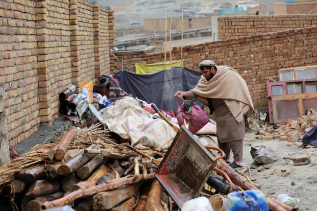 A man searches through items piled up at a house damaged by an earthquake in the village of Ittefaq, on the outskirts of Kabul, Afghanistan.