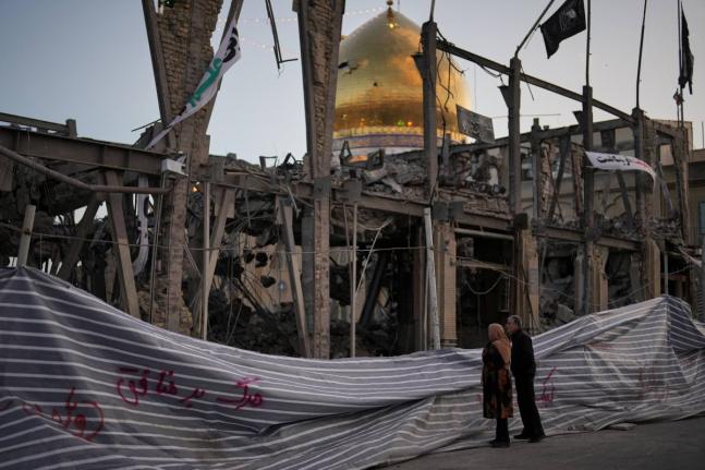 Pedestrians look at a destroyed building within the Grand Hosseiniyeh, with the mosque visible in the background, which officials at the site say was hit by US-Israeli airstrikes  in Zanjan, Iran,  on Saturday, April 4.  AP 