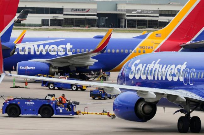 Flight line workers push a Southwest Airlines aircraft away from a gate at Love Field Airport in Dallas, Monday, March 16, 2026. (AP Photo/Tony Gutierrez)