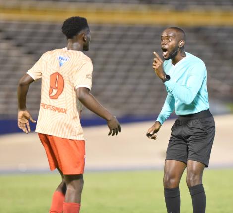 
Referee Oshane Nation (right) remonstrates with Roino Gordon during the Manning Cup final against Hydel High School at the National Stadium in 2023.