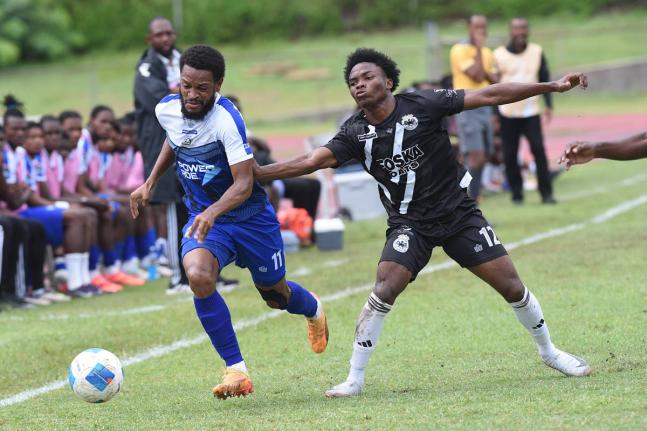 Alex Marshall (left) of Mount Pleasant dribbles away from Cavalier’s Kimarly Scott  during their Jamaica Premier League match at the Stadium East field yesterday. Mount Pleasant won 3-1.