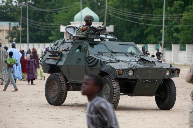Nigerian soldiers ride on an armored personnel carrier during Eid al-Fitr celebrations in Maiduguri, in Borno state, Nigeria om August 8, 2013. (AP Photo/Sunday Alamba, File)