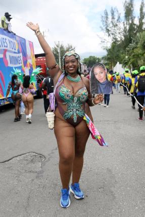 Kia-Simone Bell of Yard Mas parades along East Kings House Road on Sunday, carrying a photo poster of her absent friend while celebrating Carnival in Jamaica’s road march.