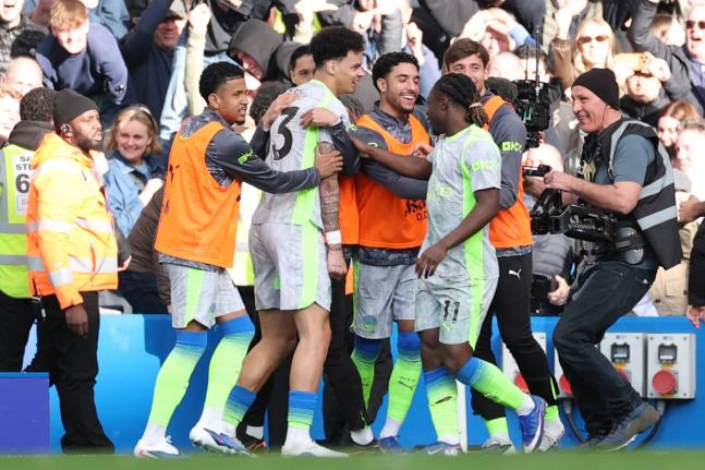 Manchester City players celebrate after a goal by Nico O’Reilly (centre) during the English Premier League  match against Chelsea in London, England, yesterday.