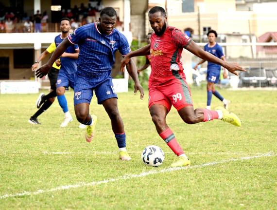 Montego Bay United’s Brian Brown (right) prepares to kick the ball as Spanish Town Police FC’s Shamar Harris reacts during their Jamaica Premier League football game at Jarrett Park in Montego Bay yesterday. Montego Bay United won 6-0.