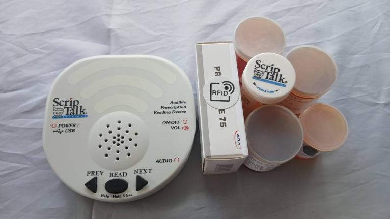 The ScripTalk device and medication containers with the Radio Frequency Identification (RFID) technology tags. The assistive technology reads prescription information aloud, helping persons who are blind, visually impaired, or have reading challenges manag