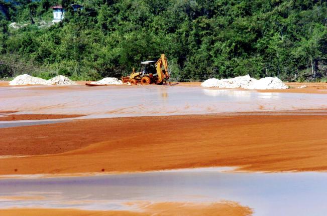A tractor uses marl to raise the height of the bank at the red mud lake in Manchester, belonging to West Indies Alumina Company (WINDALCO). (Norman Grindley)