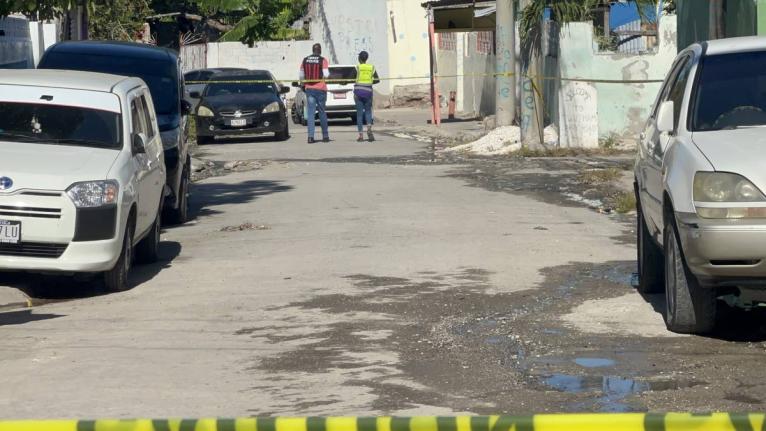 A police investigator and an investigator from the Independent Commission of Investigations (INDECOM) at the scene of a fatal police shooting in the Waltham area of St Andrew on April 15, 2026.