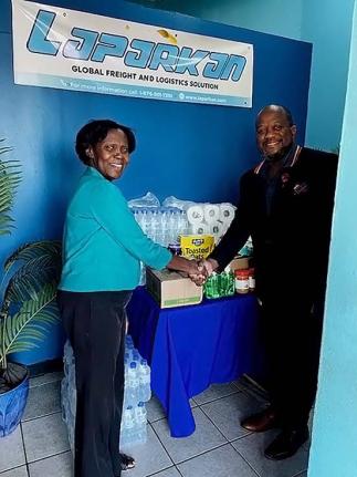 Jennifer Gordon, Laparkan Shipping’s administrative and maintenance manager, hands over essential items to Fabian White, a representative from the Ministry of Finance and Civil Service Group. Mr. White spearheaded the outreach to the private sector for d