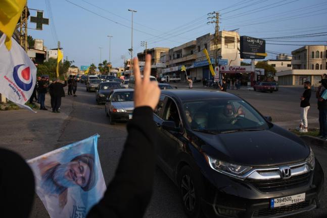 Displaced residents drive back to their villages as locals wave Hezbollah flags and an image of late Hezbollah leader Hassan Nasrallah, in Zefta, southern Lebanon, Friday, April 17, 2026, following a ceasefire between Israel and Hezbollah. (AP Photo/Hassan