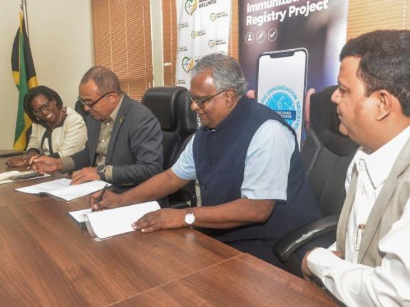 Minister of Health and Wellness, Dr. the Hon. Christopher Tufton (second left) and Managing Director of ArguSoft America Incorporated, Ram Gopalan (second right), sign the contract for the implementation of the Electronic Immunisation Registry (EIR) Projec