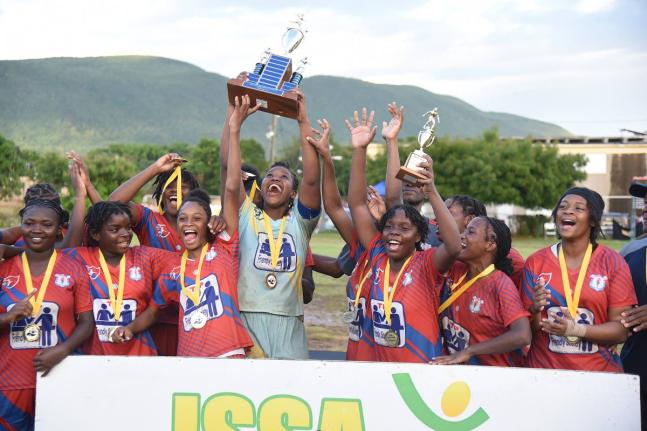 Members of the Camperdown High football team celebrate with the championship trophy after defeating defending champions Excelsior High in the ISSA high school girls’ football final at Wolmer’s Girl’s yesterday.
