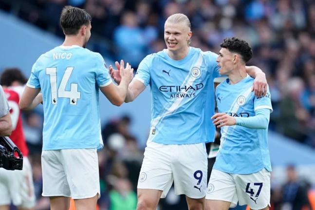 Manchester City's Erling Haaland celebrate with his teammates Nico Gonzalez and Phil Foden at the end of the English Premier League football match between Manchester City and and Arsenal, in Manchester, England, Sunday, April 19, 2026. (AP Photo/Dave Thomp