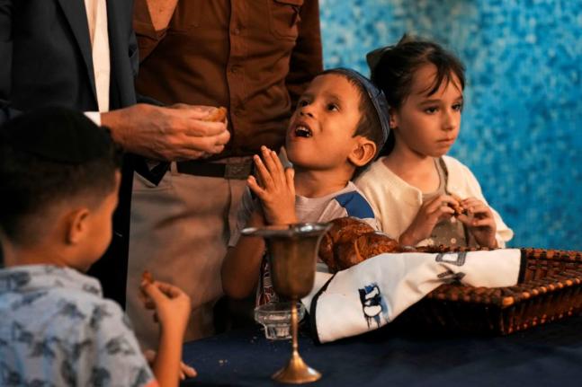 Jewish children eat pieces of Callahan bread after the prayer was recited during a Shabbat service at the Beth Shalom synagogue, in Havana, Cuba.
