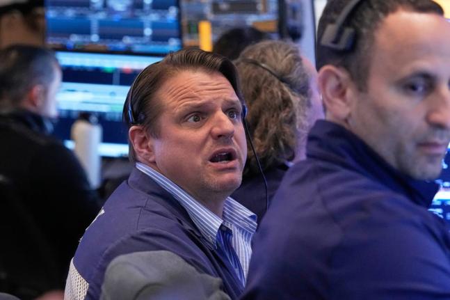 Trader Michael Milano, left, works on the floor of the New York Stock Exchange, Monday, April 20, 2026. 
