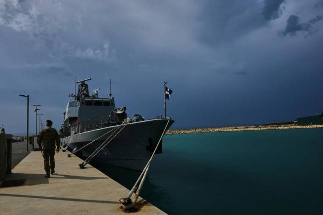 A Cyprus’ military officer walks by a frigate at the Evangelos Florakis naval base in Mari, Cyprus, on April 17.