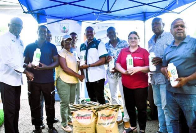 Minister of Agriculture, Fisheries and Mining, Floyd Green (centre), Representative of the Food and Agriculture Organization (FAO) of the United Nations in Jamaica, the Bahamas and Belize, Dr Ana Touza (third right), present farmers with agricultural input