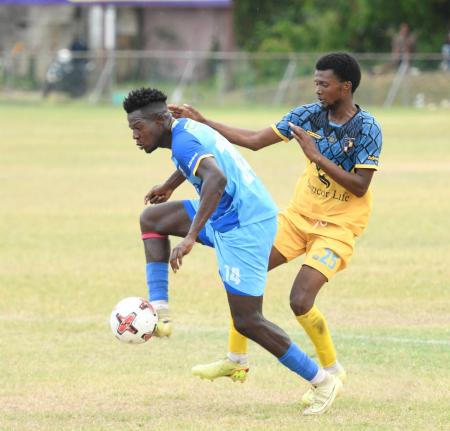 Tyrone Mullings of Racing United FC (right) attempts to tackle Sergei Ferguson of Molynes United FC during a Jamaica Premier League fixture at the Ferdi Neita Sports Complex in Portmore, St Catherine, yesterday. Molynes came away 2-1 winners.
