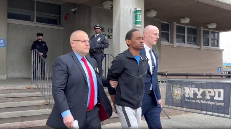 Zahir Davis, 18, getting walked out of the 113th Precinct in Queens, New York, on Saturday.