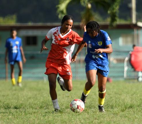 Ksystina Patterson of UWI women’s FC (left) attempts to tackle Kai Phillips of Real Mona FC during the Jamaica Women’s Premier League fixture at UWI Mona Bowl yesterday. Mona won 2-0.