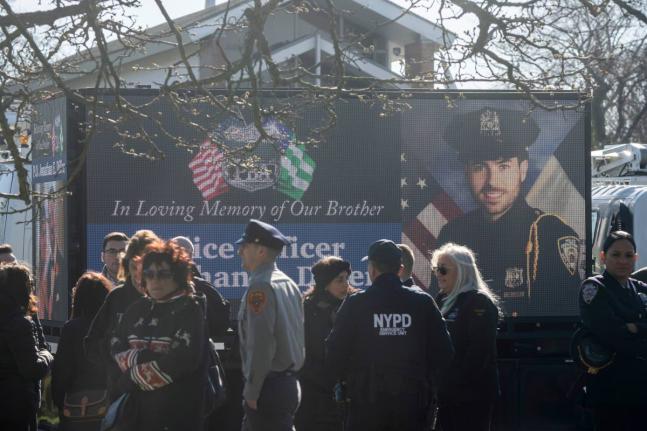 New York Police Department Officer Jonathan Diller is on a screen during his funeral service at Saint Rose of Lima R.C. Church in Massapequa Park, N.Y., March 30, 2024. (AP Photo/Jeenah Moon, File)