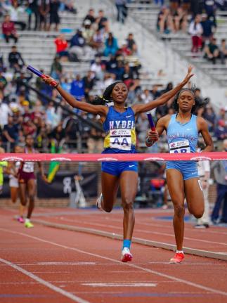 Hydel High School’s Nastassia Fletcher raises her arms as she crosses the finish line to win the Championship of America 4x400 metres at the Penn Relays inside Franklin Field Stadium in Pennsylvania on Friday. Edwin Allen’s Marria Crossfield finishes s
