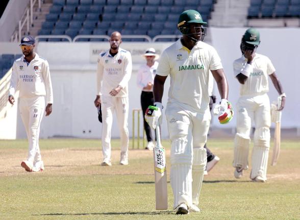 Jamaica Scorpions batsman Javelle Glenn (second right) walks off the field on day two of the West Indies Championship cricket match against the Barbados Pride at Sabina Park, in Kingston yesterday.