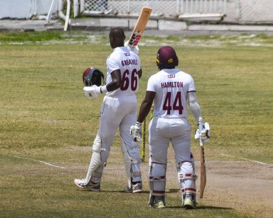 Leeward Islands Hurricanes batsman Justin Greaves (left) celebrates scoring a fighting century against the Trinidad and Tobago Red Force in a West Indies Championship cricket game at the Antigua Recreation Ground yesterday. With him is Jahmar Hamilton, who