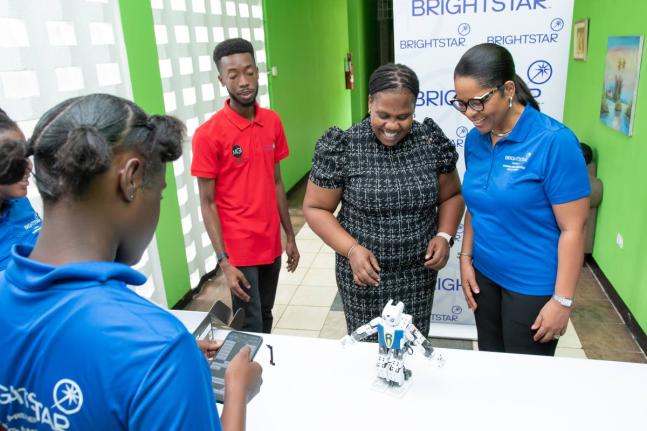 Debbie Green (right), general manager of Brightstar Lottery Jamaica, shares a light moment as a camper puts a robot through its paces during the sixth annual Coding and Robotics Rock! Camp presented by Brightstar Lottery. The free two-week programme runs s