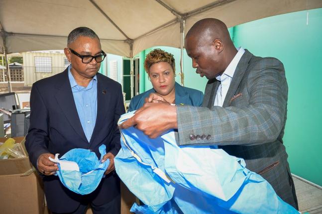 State Minister in the Ministry of Health and Wellness, Krystal Lee (centre) and Chairman, Southern Regional Health Authority (SHRA), Michael Stern (left) look on as United Kingdom (UK)-based Jamaican businessman Branatic Neufville highlights the features o