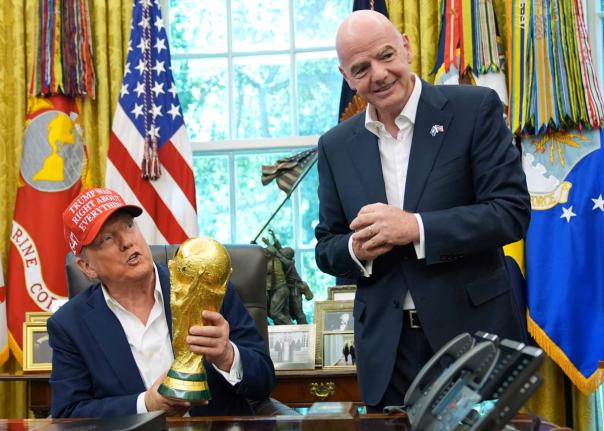 President Donald Trump holds the FIFA World Cup Winners’ Trophy as FIFA President Gianni Infantino looks on during an announcement in the Oval Office of the White House on August 22, 2025.