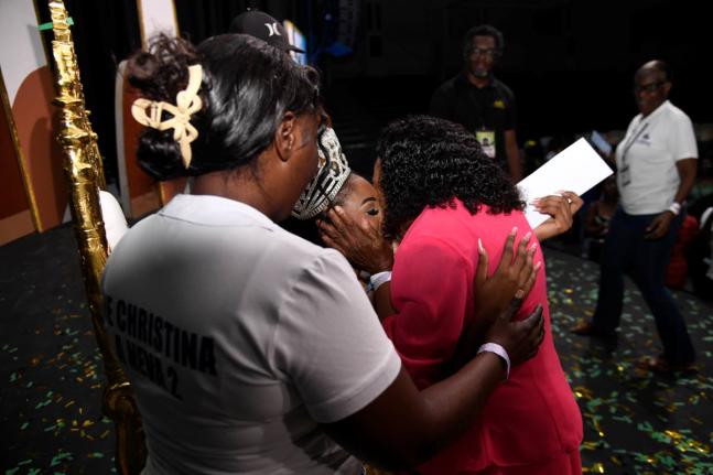 Christina Williams (centre), Miss Jamaica Festival Queen 2026, gets a kiss from her grandmother, Carmen Mcpherson (right) as her stepmother, Lasandra Williams (left), looks on during the coronation ceremony on Saturday night at Independence Village.