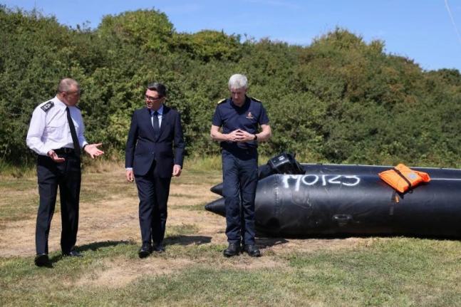 Britain’s Prime Minister Andy Burnham (centre) speaks with interim Chief Coastguard John Craig and Border Security Commander Duncan Capps beside a recovered migrant boat during a visit to HM Coastguard’s Maritime Rescue Coordination Centre in Dover, En