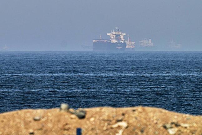 Cargo ships are seen at sea near the Strait of Hormuz.  - AP photo