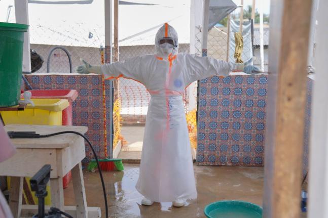 A health worker waits to be sprayed with disinfectant at the treatment centre in Bunia General Hospital in Ituri, eastern Congo, Tuesday.
