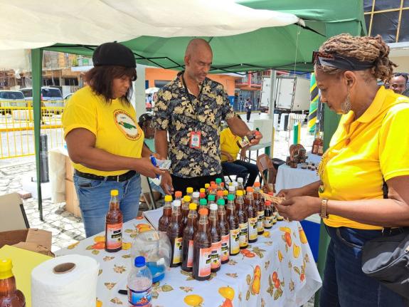 Hugh Smith (centre), chief plant protection officer in the Ministry of Agriculture, Fisheries, and Mining’s Apiculture Unit, looks through bottles of honey and honey-related products, during Thursday’s fourth annual staging of the St James Bee Farmers 