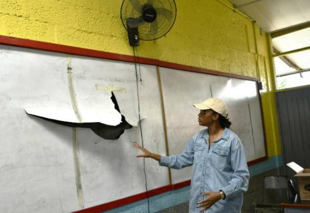 Minister of State in the Ministry of Education, Skills, Youth and Information, Rhoda Moy Crawford, shows one of the damaged whiteboards at Albert Town Primary and Infant School in Trelawny, which will be replaced as part of repairs now taking place at the 