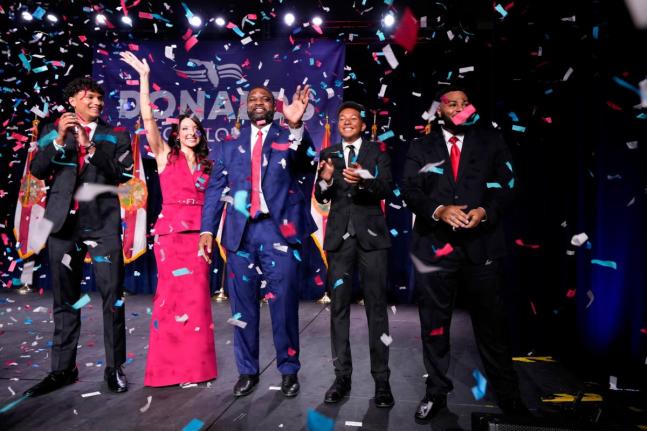 Florida Republican gubernatorial candidate Byron Donalds (center) waves next to his wife Erika, while standing on stage with their children Darin (left), Damon (second from left), and Mason at a primary election party on Tuesday in Orlando, Florida, United