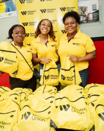 From left: GraceKennedy Money Services (GKMS) team members Vanessa Gilbert, Abigail Burt and Vanessa Lyons prepare to distribute back-to-school care packages to customers at GKMS East Parade during the One More Step Location Tour. Through the initiative, G