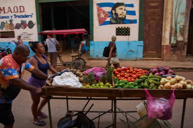 Street vendors push their cart of vegetables past a mural of Fidel Castro in Havana, Cuba, August 12.