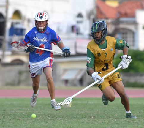Owen Stephenson (right) of Jamaica, moves clear of  Puerto Rico’s Ryan Stowell during the Pan American Men’s Lacrosse Championship match  at the Stadium East field yesterday.