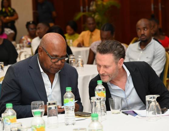 From left: Edmund Bartlett (left), minister of tourism, and Leo Schlesinger, chief executive officer of Tortuga Resorts, in conversation  at the East Central St James 30th Annual Tertiary Awards held at the Montego Bay Convention Centre last Thursday. 