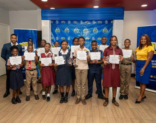 Bert Tomlinson Jr (left), director, Bert’s Auto Parts Foundation, and Roxanne Edwards-Chambers (right), junior human resources officer, Bert’s Auto Parts, celebrate with 16 young achievers receiving scholarships and grants from the foundation as part o