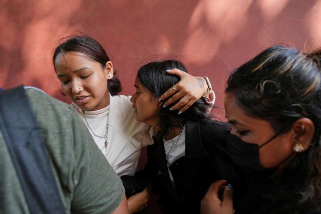 A relative consoles Jenisha (center) as she cries while waiting for the news of her father missing after flash flooding in Nepal's Nuwakot district on Friday. - AP photo