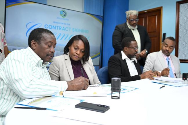 Minister with Responsibility for Land Titling and Settlements in the Ministry of Economic Growth and Infrastructure Development, Robert Montague (left), signs contracts for the construction of semi-permanent housing solutions for Hurricane Melissa-affected