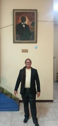 Rev’d Ignacio Barrera Kelly of San Andres, Colombia, stands beneath a portrait of George Liele on the compound of the East Queen Street Baptist Church. Liele, a Black American, is credited with founding the Native Baptist movement in Jamaica.