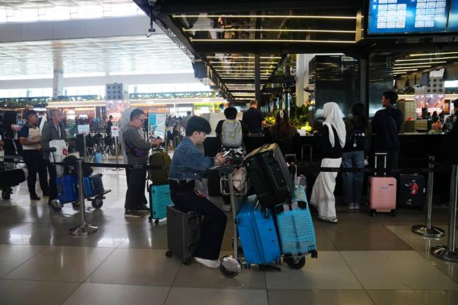 Travelers wait for their flights at Soekarno-Hatta International Airport in Tangerang, Indonesia.
