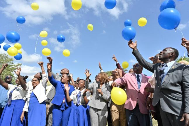 Senator Dana Morris Dixon, (centre)  Minister of Education; Carlon Pitt, (second right) Principal of the School; Dr. Walton Small, (right) Retired Principal of Hydel High and Icylin Golding, (second left) Custos Rotolorum of St. Catherine and students rele